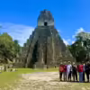 Small tour group posing in front of Temple I at Tikal in Guatemala